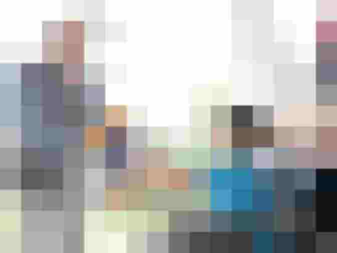 Ein älterer Mann überreicht einem Jungen im Rollstuhl ein Plüschtier des Lions Clubs.